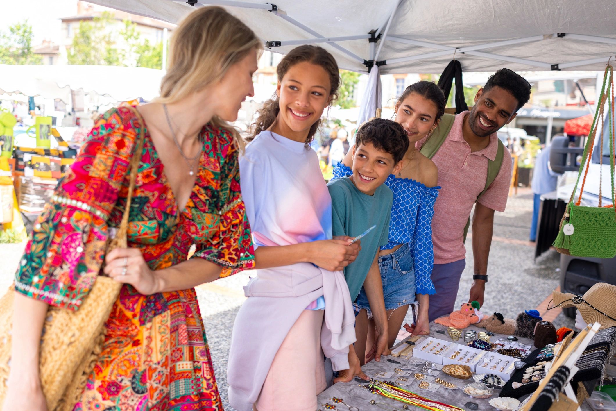 Family browsing handcrafted items at a market stall