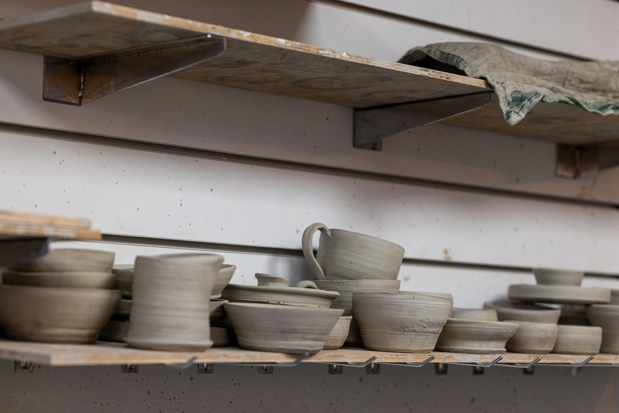 Shelves of handmade ceramic pieces ready for finishing