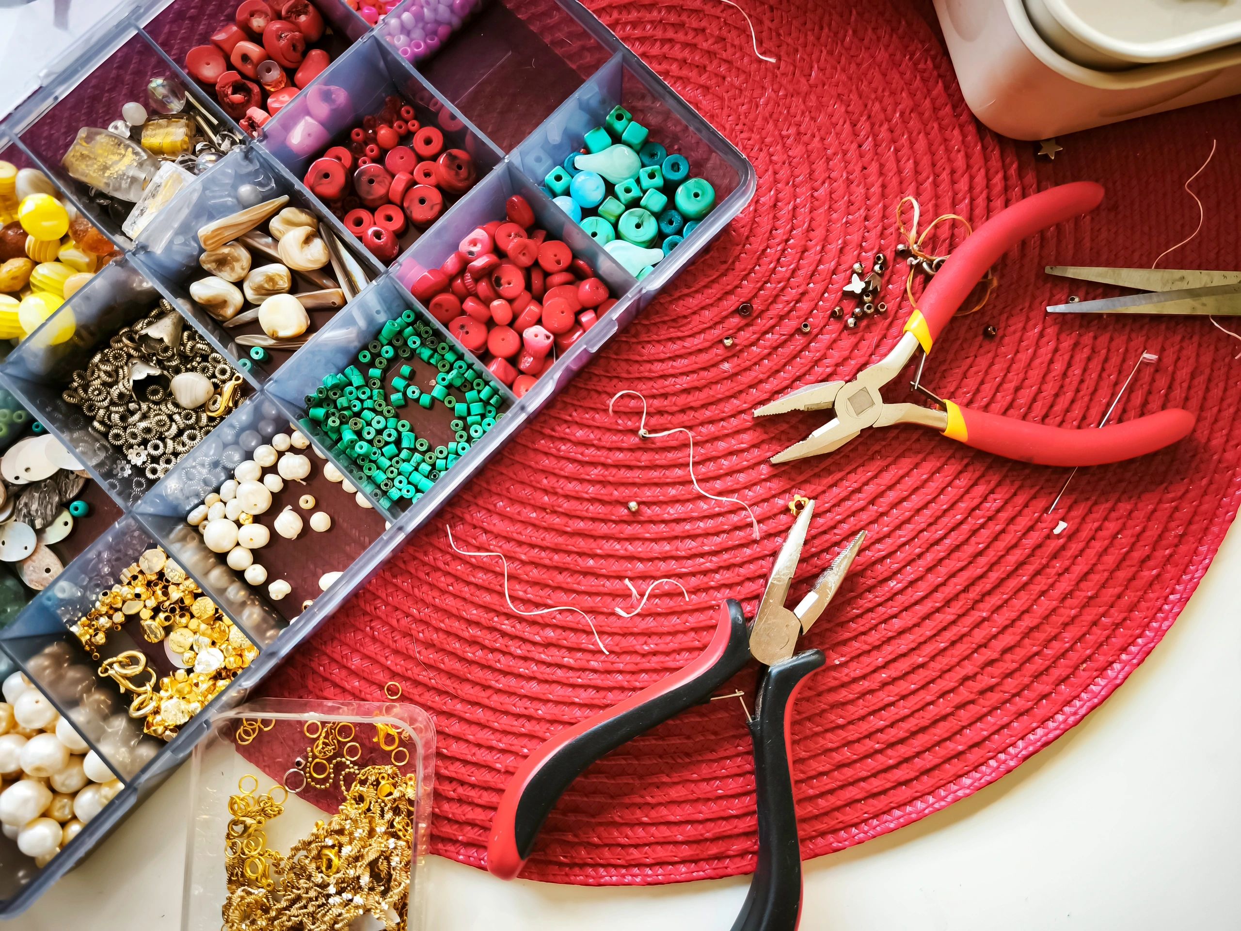 Jewelry-making workspace with beads, stones, and tools